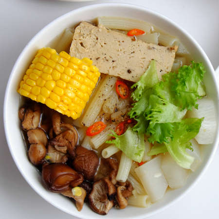 Top view Vietnamese vegan food for diet meal, vegetarian macaroni soup bowl with raw material as radish, mushroom, corn, salad, non meat eating good for healthの写真素材