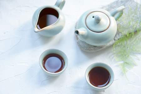 tea pot set close up view with cups filled with chinese teaの写真素材