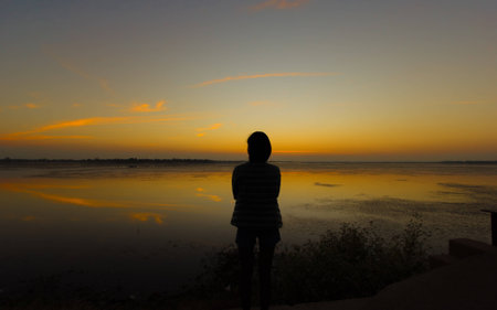 silhouette a girl by the reservoir , surin, thailandの写真素材