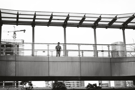 a boy Search route by phone standing on the bridgeのeditorial素材