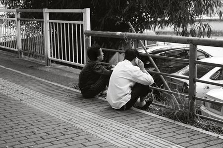 two man sit down beside roadのeditorial素材