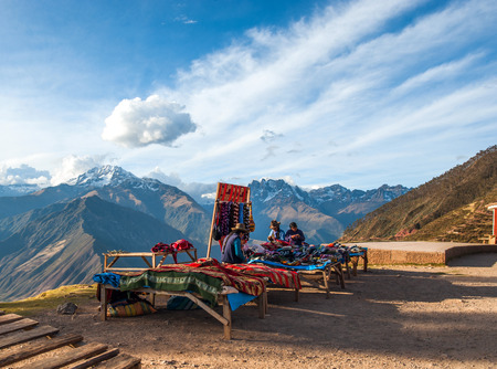 URUBAMBA, PERU - AUGUST 3, 2011: Indian women in national clothes sells the products of her weaving in the tourist spot of Sacred Valley on the road from Cuzco to Abancay on August 3, 2011 in Urubamba, Peruのeditorial素材