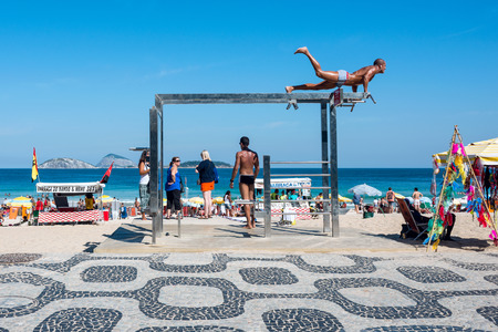Rio de Janeiro, Brazil - July 24, 2016: Young man at one of the many outdoor fitness stations on Ipanema Beachのeditorial素材
