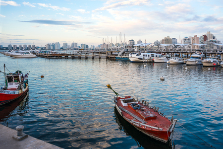 Maldonado, April 4, 2017 - Classic Red Fishing Boat moored in front of the yachts of the rich people in Punta del Este harbor, Uruguayのeditorial素材
