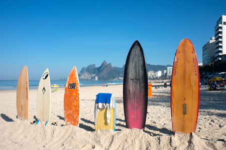 Rio de Janeiro, Brazil - July 24, 2016: Surfboards standing upright in bright sun on the Ipanema beachのeditorial素材