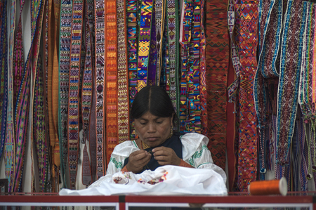 Otavalo, Ecuador - July 5, 2012: Indian women in national clothes sells the products of her weaving, as usual on weekdays on the most famous markets in South America, on August 4, 2012 in Otavalo, Ecuadorのeditorial素材