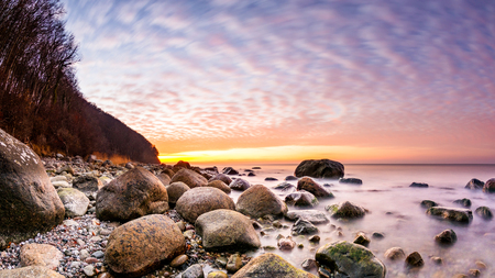 Sunset on a rocky beach at the oceanの写真素材