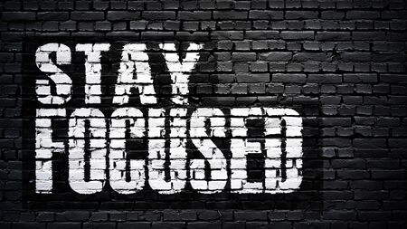 Stay focused, motivation slogan, white text on black brick wallの写真素材