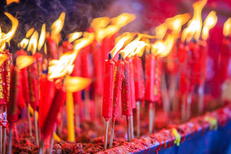 Burning red Chinese candle or stick in temple.の写真素材