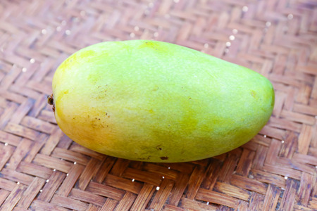 Fresh golden mango in basket on wood tableの写真素材