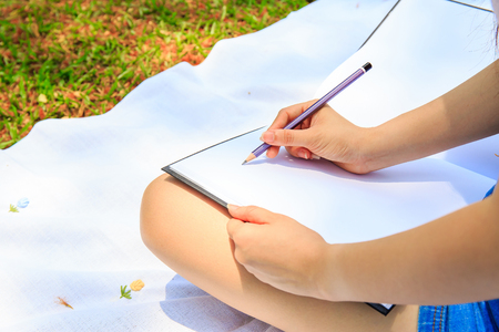 Hand of pretty women or girl write something in notebook with a pencil.の写真素材