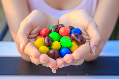 colorful chocolate in women or girl handの写真素材