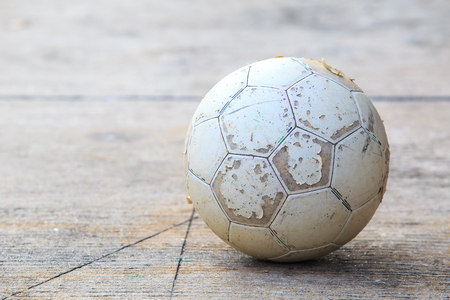 Classic old ball football on concrete floor with sun shadow.の写真素材