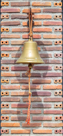 vintage iron bell with red brick wallの写真素材