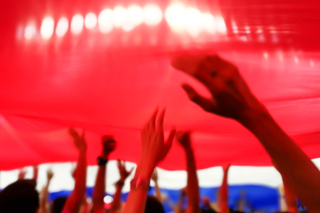 Blurry abstract image of fan football or soccer cheer under Thailand flag with blurry hand and head at the stadium when their team got a score.の写真素材