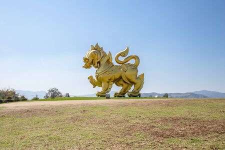Chiangrai, Thailand. - February 25, 2017 : The statue of golden lion on a field with blue sky background, at Singha park Chiangrai Thailand.のeditorial素材