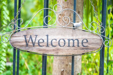 Welcome sign on the iron door or fence. made from wooden.