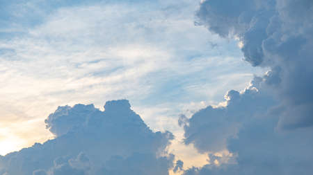 Dramatic sky of golden or yellow sunset light with blue sky and white clouds at evening time.の写真素材