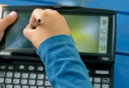 child writing an typing on a PDA の写真素材