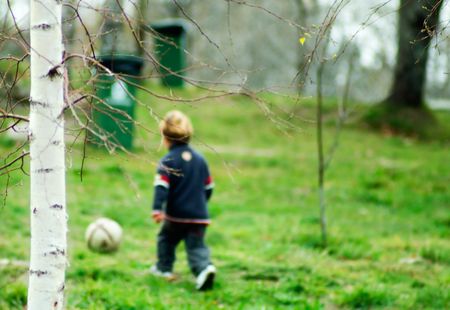 a boy playing soccer in the forestの写真素材