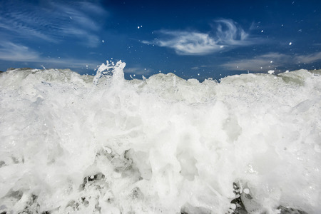 Powerful ocean breakwater with white spume and blue skyの写真素材