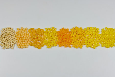 different yellow plastic polymer resin granules in laboratory