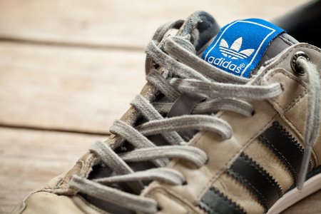 Used classic adidas shoe on old wood floor. This file is cleaned and retouched.