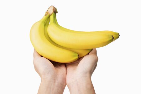 closeup of holding  fresh bananas in hands with white background.の写真素材