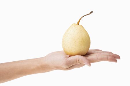 closeup of holding one fresh pear in hand with white background.の写真素材