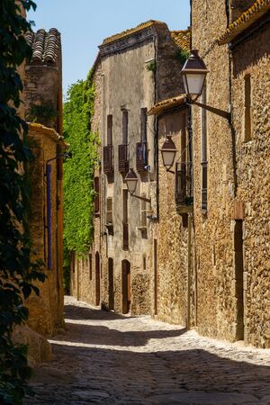 Beautifull narrow street with high buildings. Made from yellow stones. Streetlights are attached to the houses and looks magnificentの写真素材