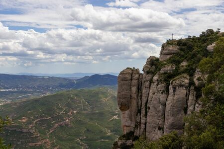Nice mountain with cross and people above. Nice view over the valley below.の写真素材