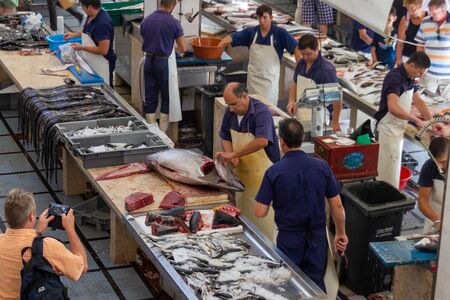 FUNCHAL, PORTUGAL - JULY 18, 2017: Prepairing tuna and other fish at fish market in Funchalのeditorial素材