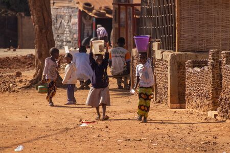 SANKANDI, GAMBIA- JAN 6, 2014: In Gambia everyone helps in the family. Here small children getting waterのeditorial素材