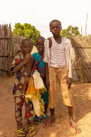 GEORGETOWN, GAMBIA- JAN 7, 2014: Poor farm boys. Smiling and wearing clothes from wrong sizesのeditorial素材
