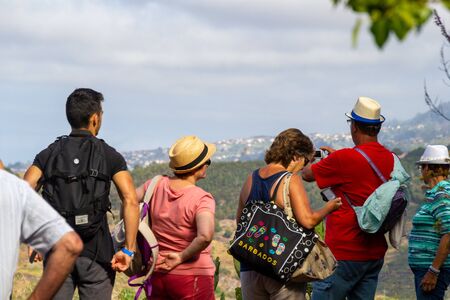FUNCHAL, PORTUGAL - JULY 14, 2017: Hiking tourists from behind enjoying the viewのeditorial素材