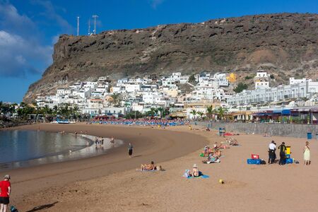 Puerto de Mogan, Spain - Jan 6, 2010: Tourists on the beach in the morning of January, enjoying and relaxing in the sunのeditorial素材