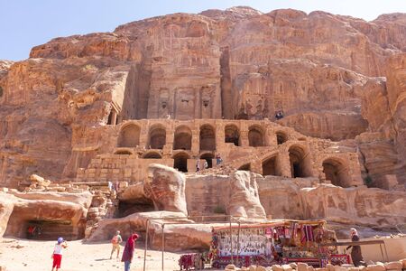 Petra, Jordan - Sept 21, 2013: Old tomb buildings carved in the mountains from Petra and bedouin selling tourist items in Jordanのeditorial素材