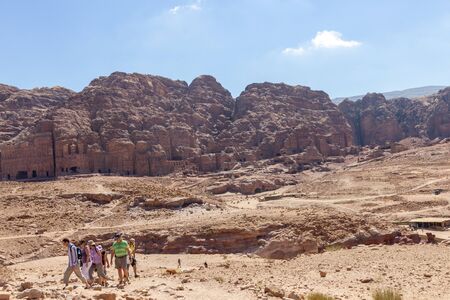 Petra, Jordan - Sept 21, 2013: Tourists walking through a valley in Petra with in the background the old tomb buildings carved in the mountainsのeditorial素材