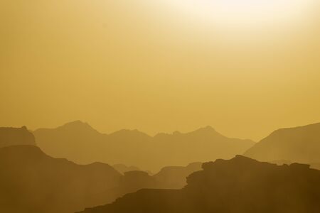 Several tints of yellow for the mountain ridges at sunset in the Wadi Rum desertの写真素材