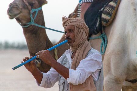 Douz, Tunisia - 8 Sept, 2014: Local musician playing flute for tourists at the Sahara desertのeditorial素材