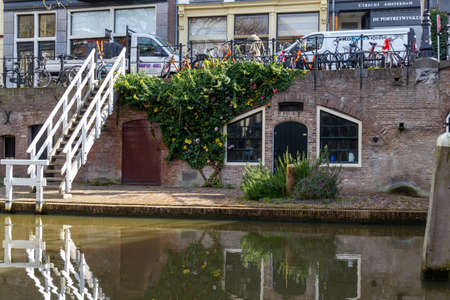 Utrecht, the Netherlands - 16 Mar, 2020: Flower bush and stairs beside the entrance to a wharf beside the Oudegracht canal in Utrechtのeditorial素材
