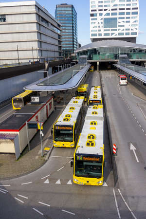 Utrecht, the Netherlands - 16 Mar, 2020: Yellow articulated busses departing from the bus station at...