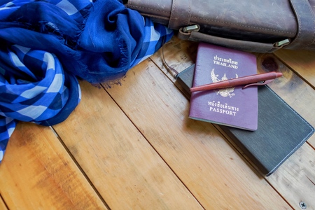 Leather brown bag passport and notebook with navy blue checked scarf.の写真素材
