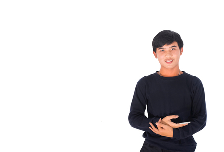 A handsome Asian man in black clothes standing in Studio white background plays his mobile phoneの写真素材
