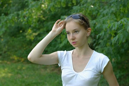 girl in a white t-shirt holding sunglassesの写真素材