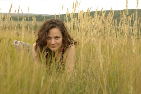 Girl lying in the autumn corn fieldの写真素材