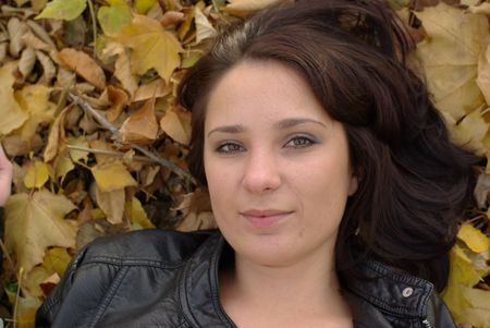 Girl lying on the autumn leavesの写真素材