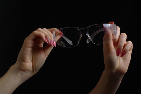 Female hands holding transparent gogglesの写真素材