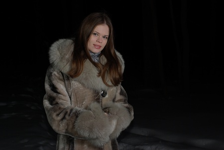 Young female walking in a winter forestの写真素材