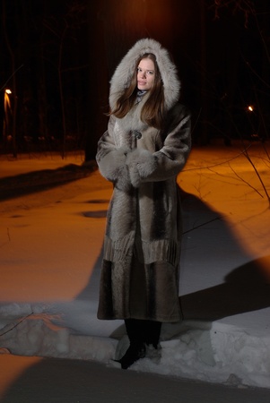 Young female walking in a winter forestの写真素材